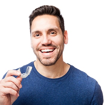 A young man with Invisalign aligners smiling