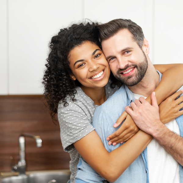A couple standing in the kitchen, embracing and smiling